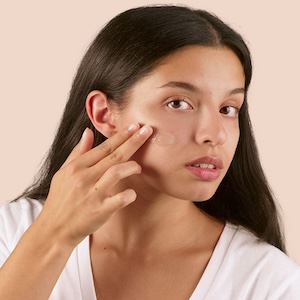 Mujer aplicando crema facial hidratante para nutrir y proteger la piel sin sensación pesada.